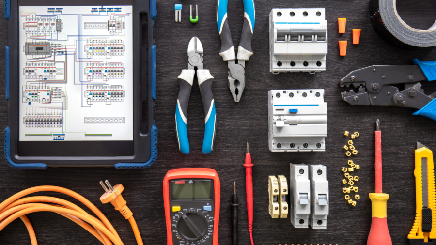 Flat lay composition with electrical tools and digital tablet on wooden background.